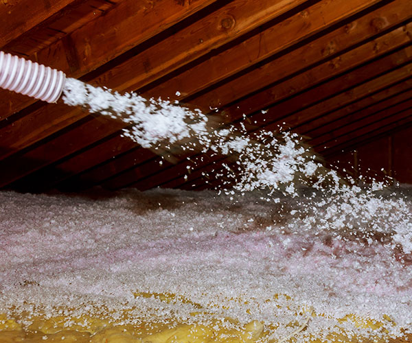 residential & commercial installation services include loose fill insulation being blown into an attic